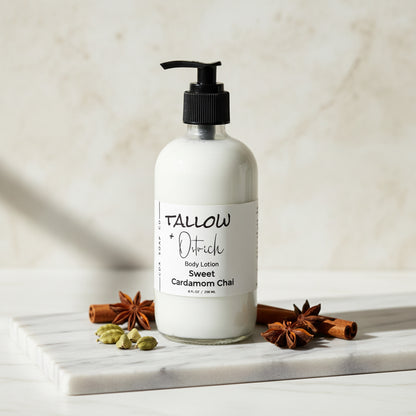 Bottle of Tallow & Dirtich body lotion on a marble surface with spices.