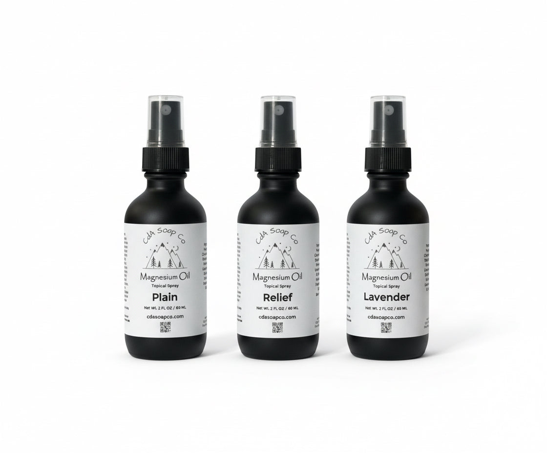 Three black spray bottles with magnesium labels on a white background