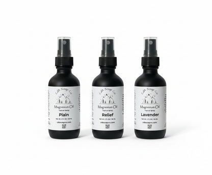 Three black spray bottles with magnesium labels on a white background