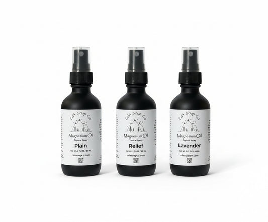 Three black spray bottles with magnesium labels on a white background