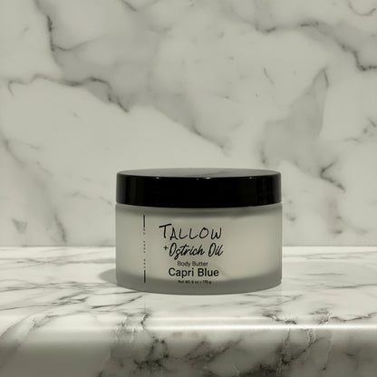 Jar of Tallow + Ostrich Oil Body Butter on a marble surface with a marble background