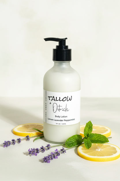 Bottle of Tallow and Ostrich oil  body lotion with lemon slices and lavender on a light background