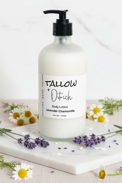 Lavender chamomile Body lotion bottle with 'Tallow & Ostrich' label on a marble surface with flowers.