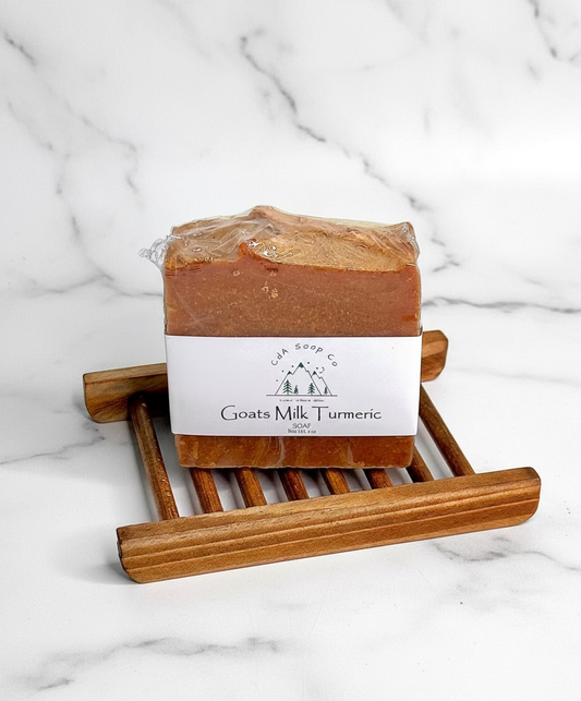 Bar of soap on a wooden soap dish with a marble background