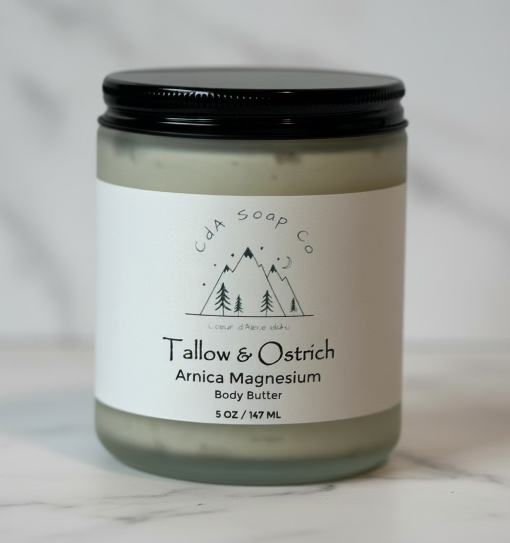 A jar of Tallow & Ostrich Arnica Magnesium Body Butter by Cda Soap Co, with a white label on a marble background.