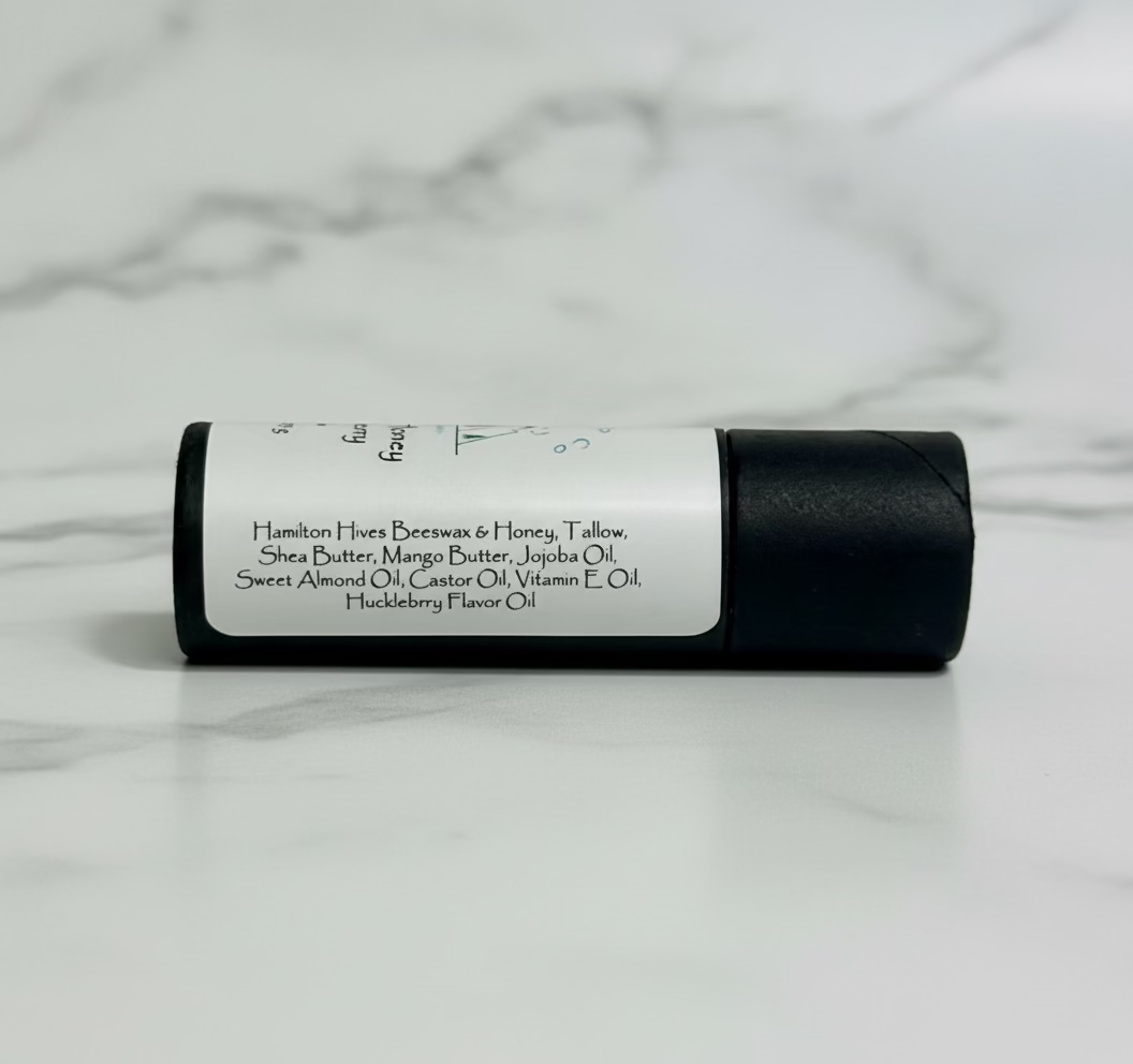 lip balm tube showing ingredients with a marble background