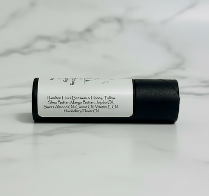 lip balm tube showing ingredients with a marble background